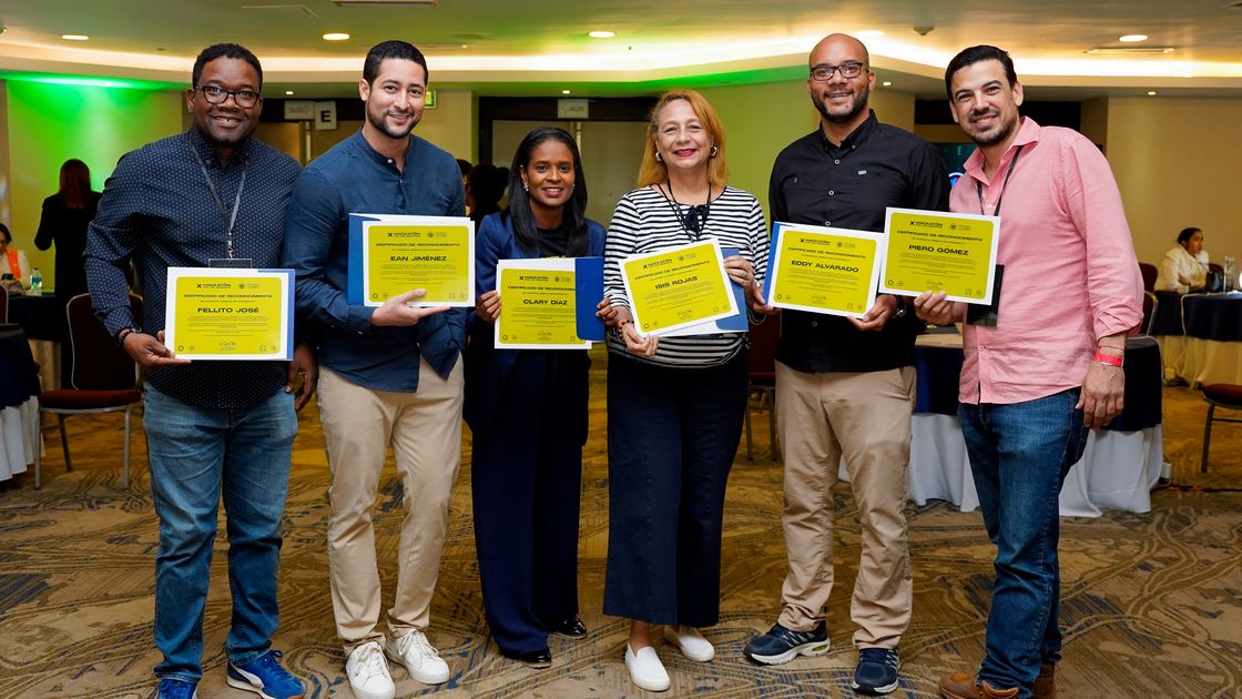 Participantes de un programa de Fundación Enlata muestran sus certificados al terminar.